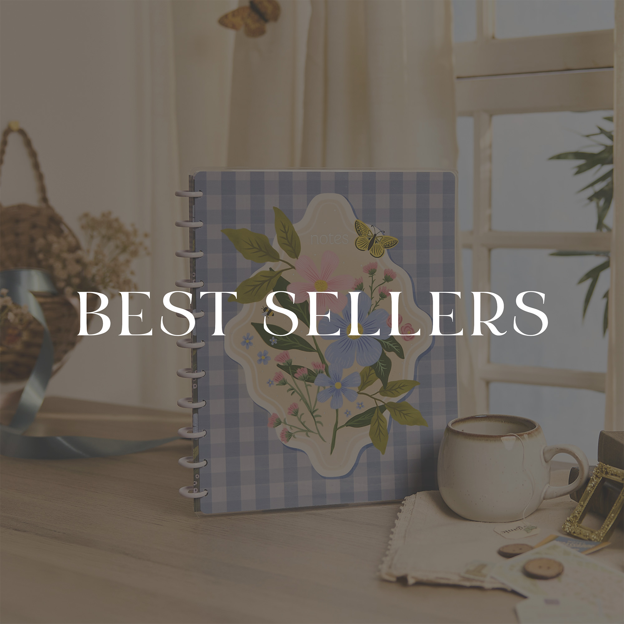 ```html
<img src=_image.html alt="Decorative notebook with floral design on a table, next to a cup. Text overlay reads 'Best Sellers'." />
```
